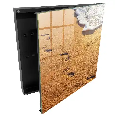 Armoire à clés plage avec des empreintes de pas près des vagues