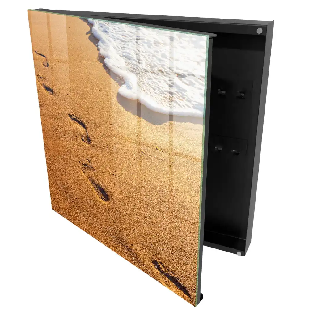 Armoire à clés plage avec des empreintes de pas près des vagues