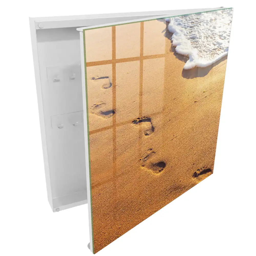 Armoire à clés plage avec des empreintes de pas près des vagues