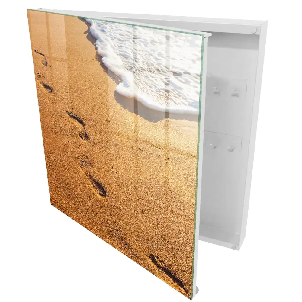 Armoire à clés plage avec des empreintes de pas près des vagues