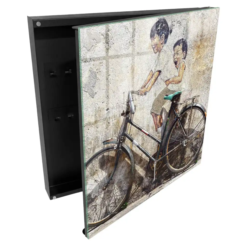 Boîte à clés murale art de rue représentant des enfants à vélo sur un vieux mur