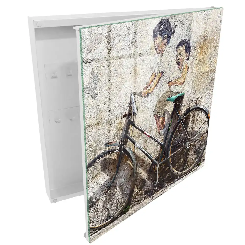 Boîte à clés murale art de rue représentant des enfants à vélo sur un vieux mur