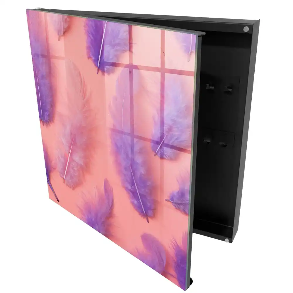 Boîte à clés plumes délicates sur un fond rose