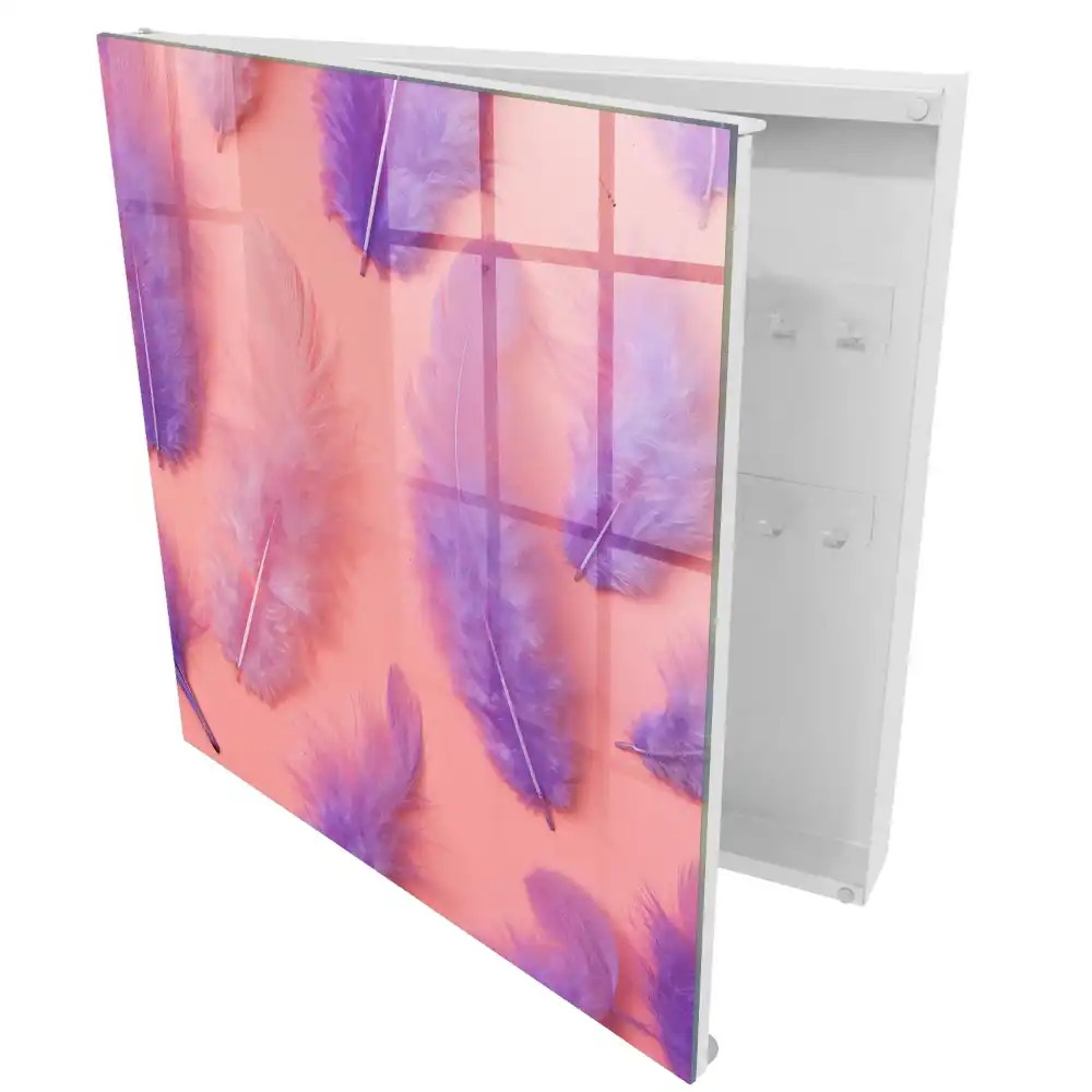Boîte à clés plumes délicates sur un fond rose