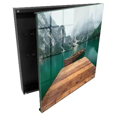 Armoire à clés un lac de montagne et un bateau entourés de sommets