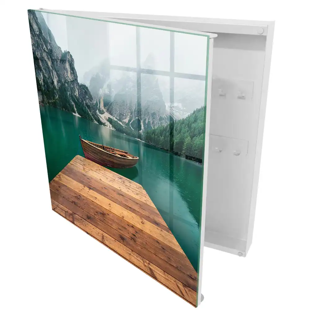 Armoire à clés un lac de montagne et un bateau entourés de sommets