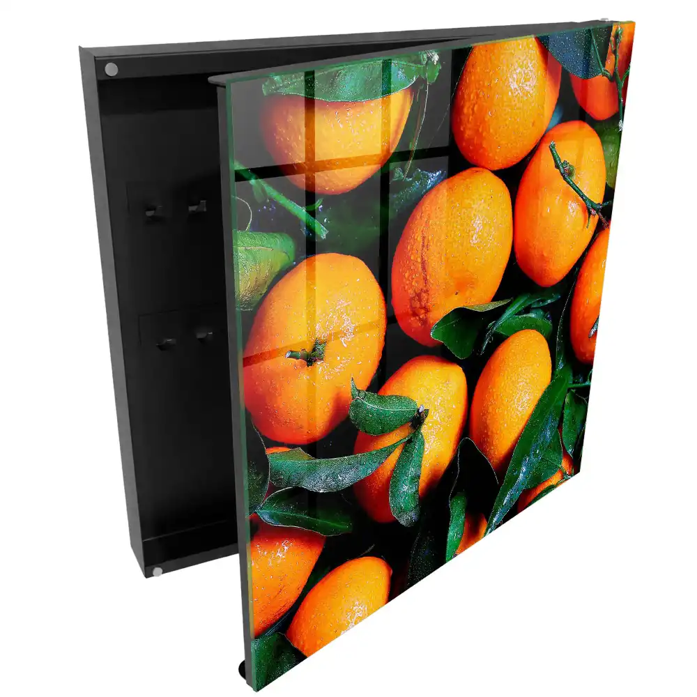 Boîte à clés des oranges juteuses parmi les feuilles vertes