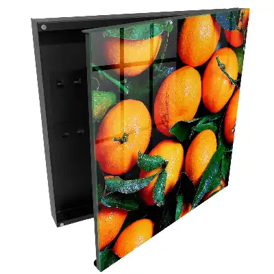 Boîte à clés des oranges juteuses parmi les feuilles vertes