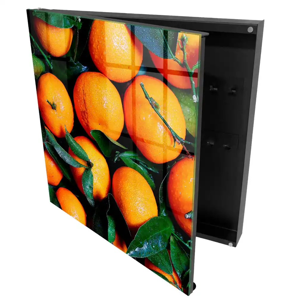 Boîte à clés des oranges juteuses parmi les feuilles vertes