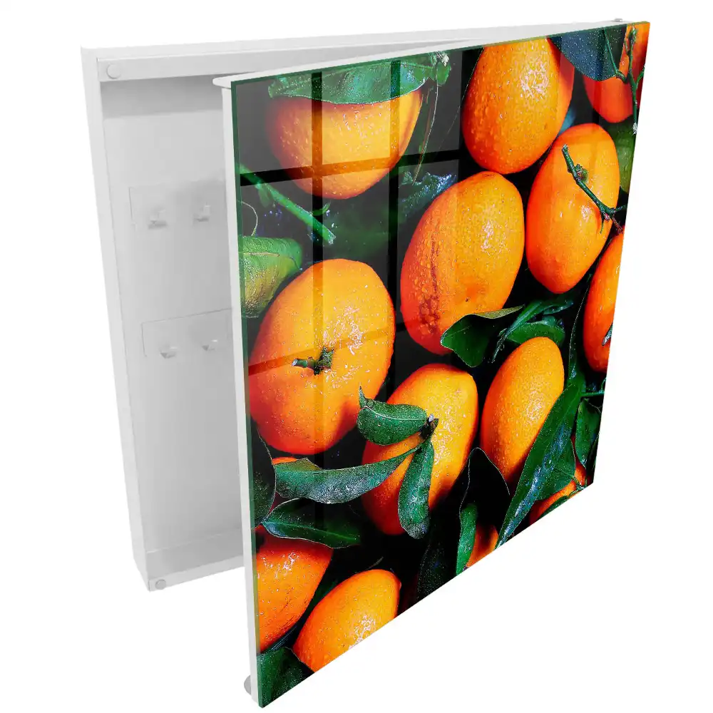 Boîte à clés des oranges juteuses parmi les feuilles vertes