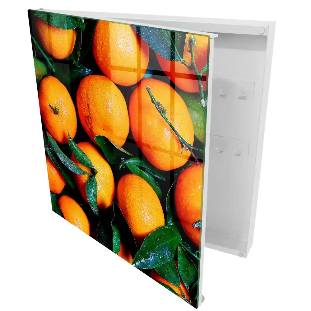 Boîte à clés des oranges juteuses parmi les feuilles vertes