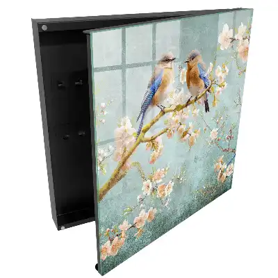 Armoire à clés oiseaux pastel sur une branche parmi les fleurs