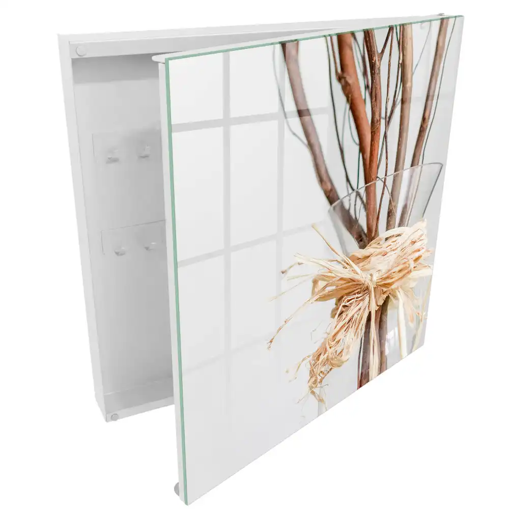 Armoire à clés branches dans un vase en verre avec une ficelle beige