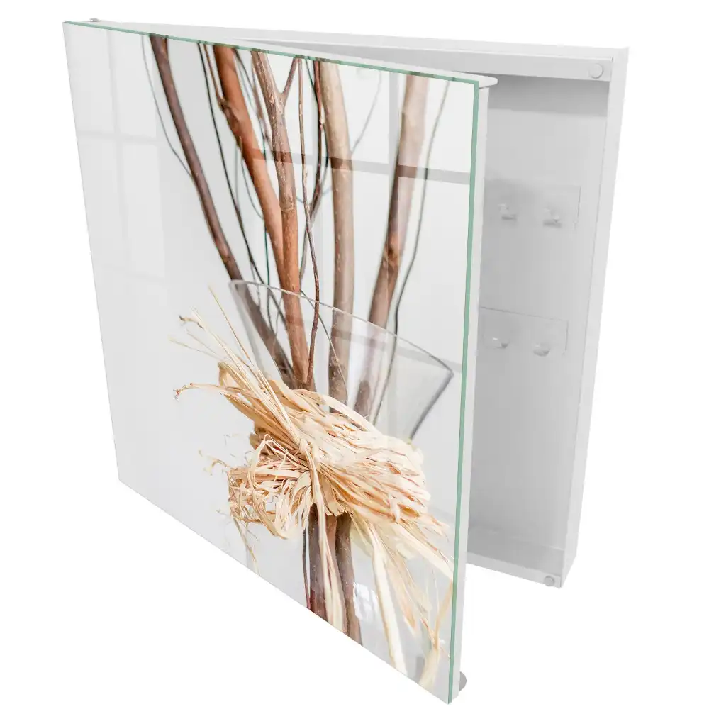 Armoire à clés branches dans un vase en verre avec une ficelle beige