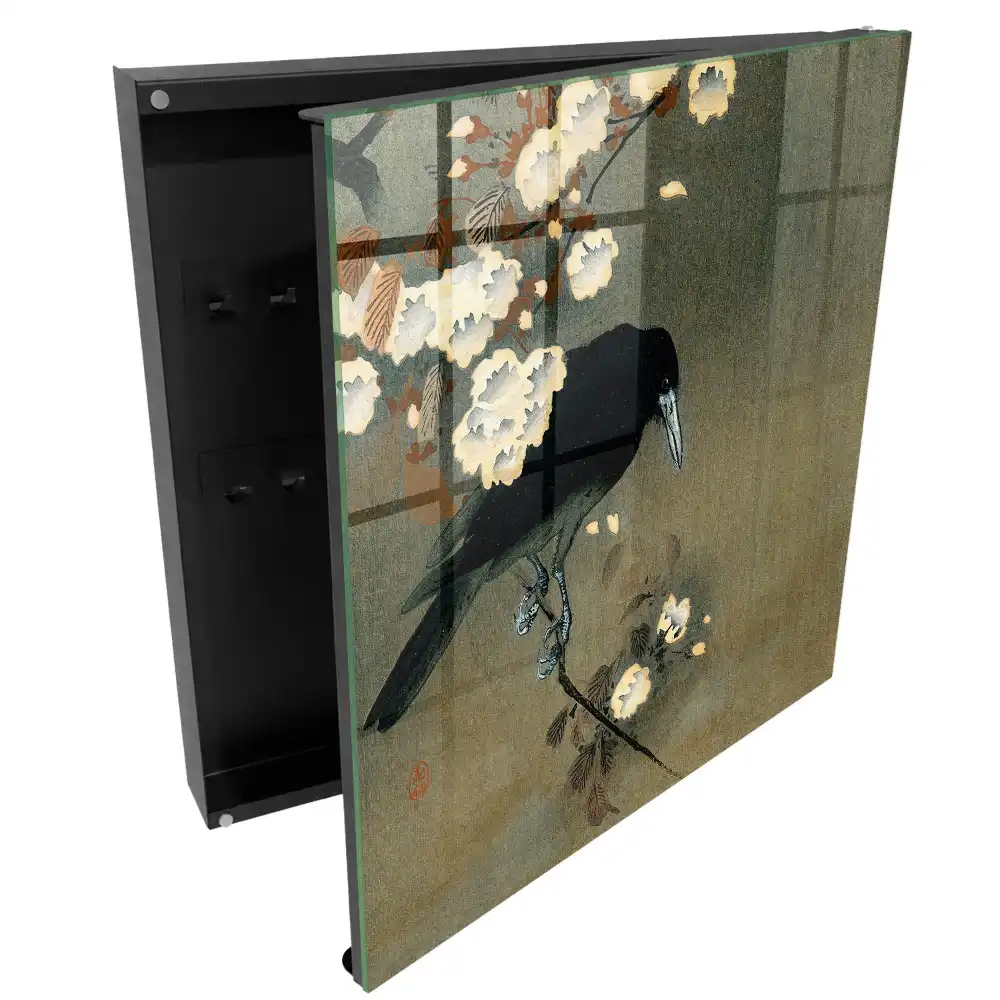 Armoire à clés un corbeau sur une branche avec des fleurs blanches