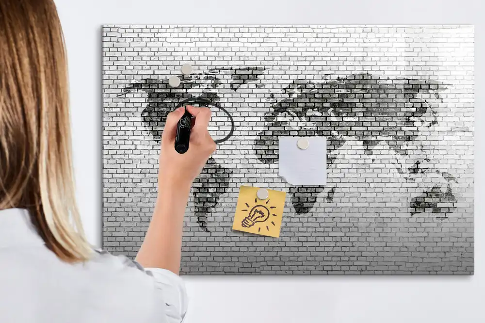 Tableau magnétique illustrant le monde sur fond de mur de briques