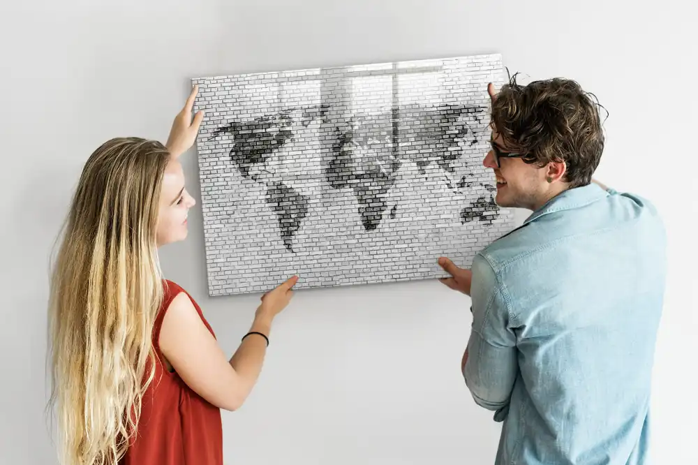 Tableau magnétique illustrant le monde sur fond de mur de briques