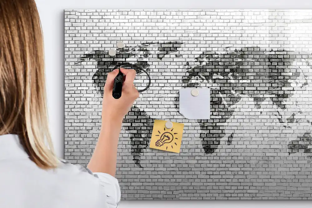 Tableau magnétique illustrant le monde sur fond de mur de briques