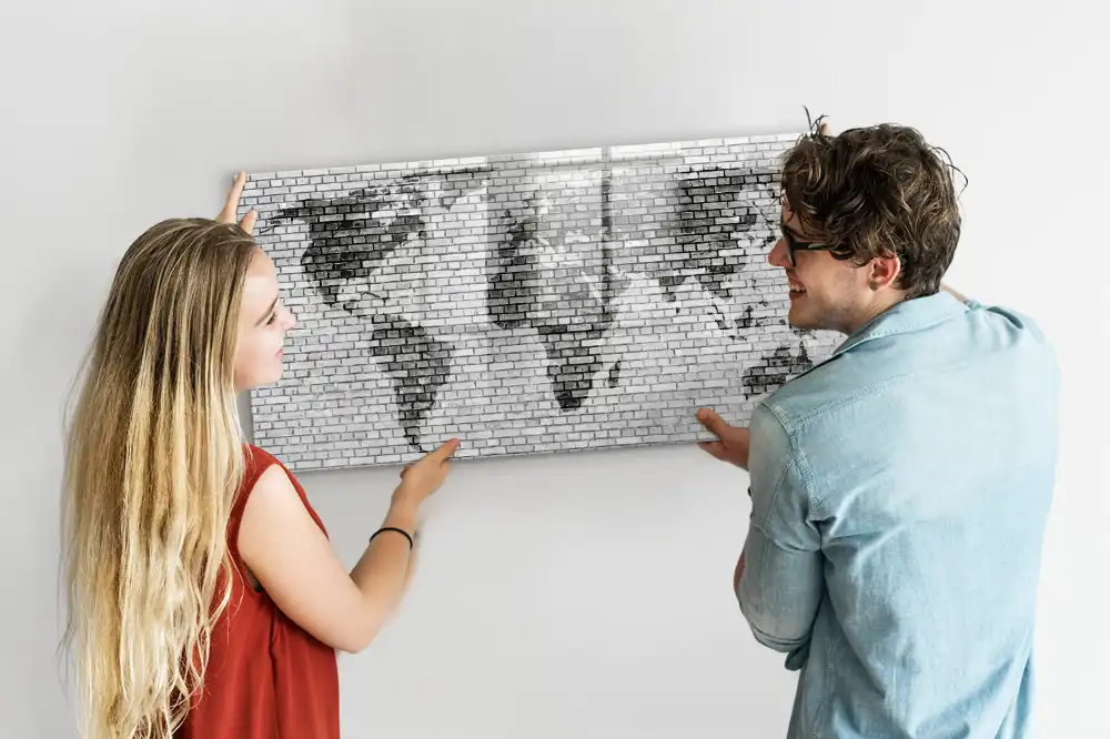 Tableau magnétique illustrant le monde sur fond de mur de briques