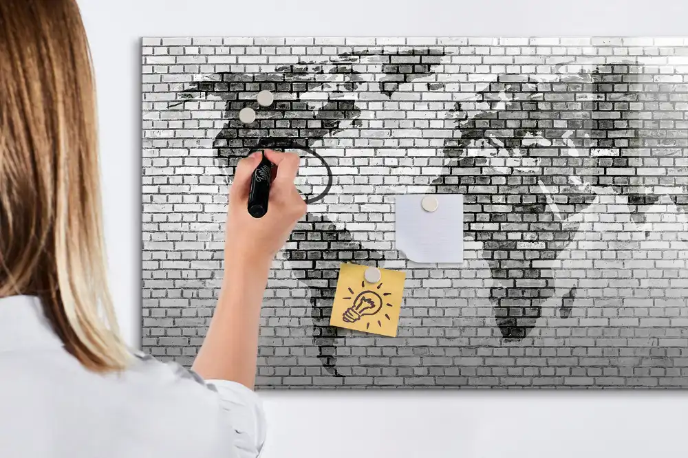 Tableau magnétique illustrant le monde sur fond de mur de briques