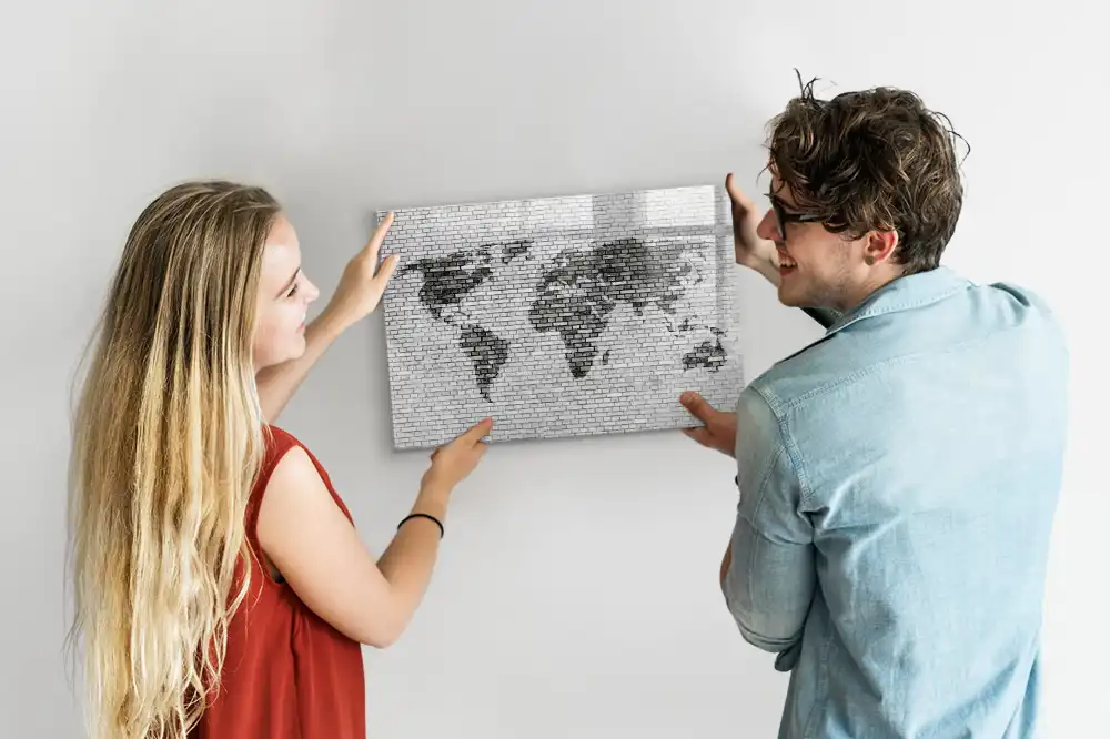 Tableau magnétique illustrant le monde sur fond de mur de briques