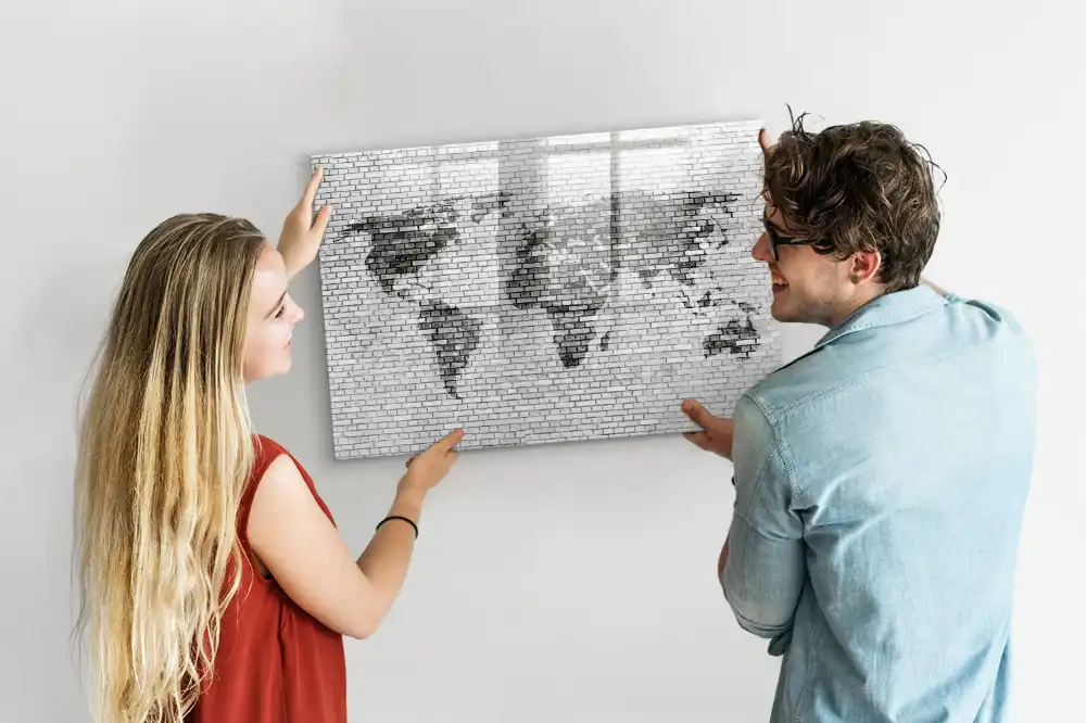 Tableau magnétique illustrant le monde sur fond de mur de briques