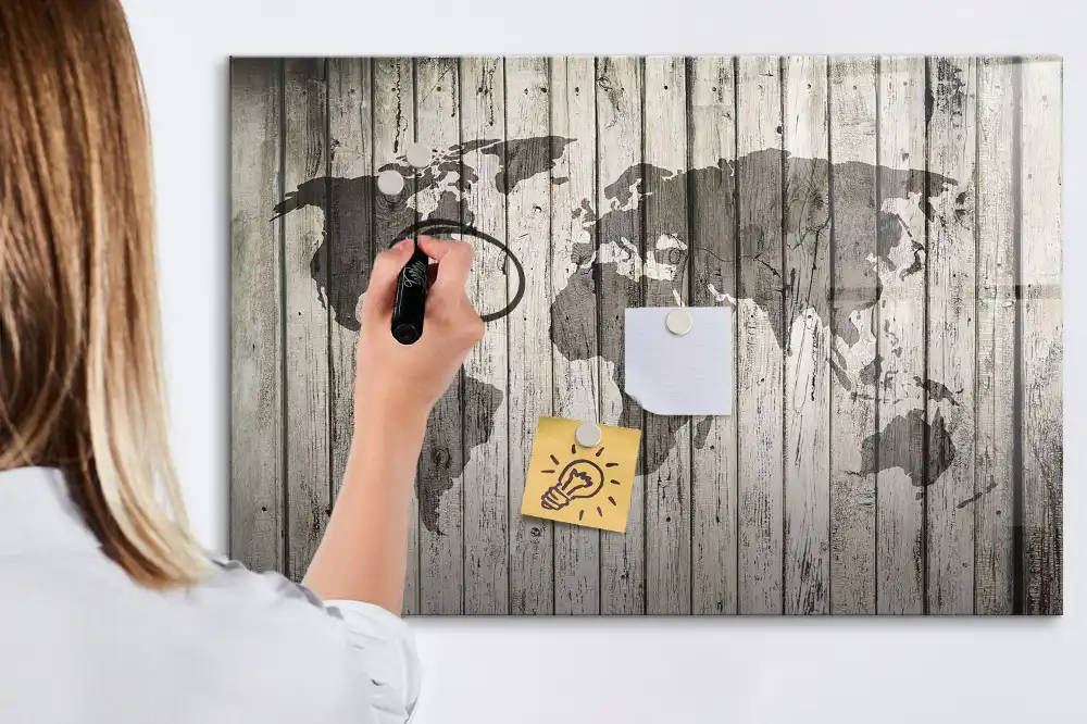 Tableau blanc magnétique effaçable à sec représentant une carte du monde sur fond de table en bois
