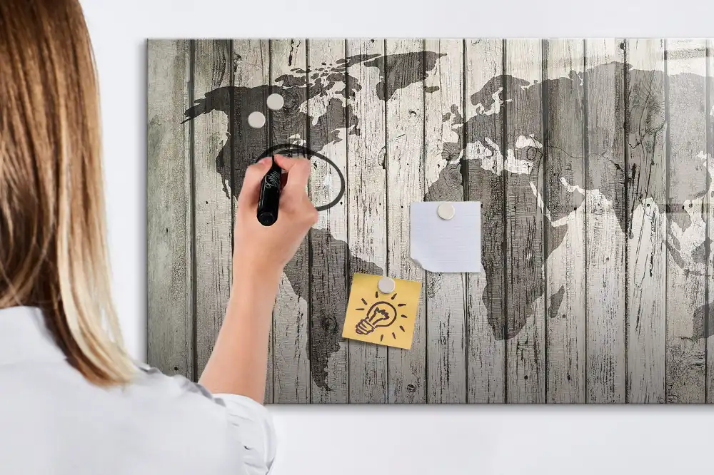 Tableau blanc magnétique effaçable à sec représentant une carte du monde sur fond de table en bois