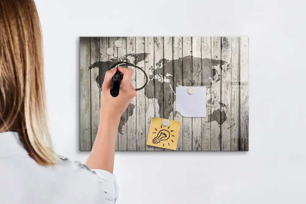 Tableau blanc magnétique effaçable à sec représentant une carte du monde sur fond de table en bois