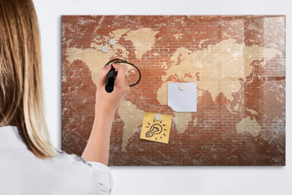 Tableau blanc magnétique effaçable à sec avec carte des continents sur fond mur de briques