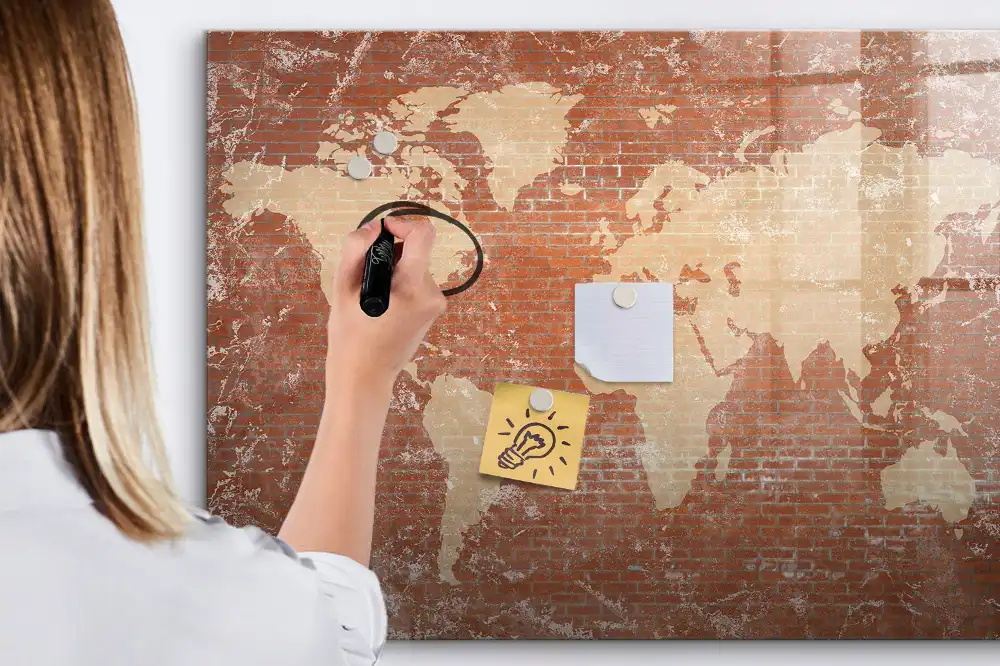 Tableau blanc magnétique effaçable à sec avec carte des continents sur fond mur de briques