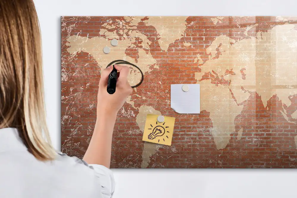 Tableau blanc magnétique effaçable à sec avec carte des continents sur fond mur de briques