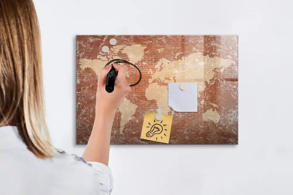 Tableau blanc magnétique effaçable à sec avec carte des continents sur fond mur de briques